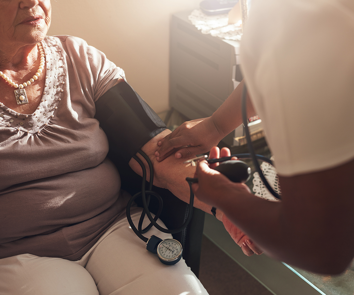 Close up shot of nurse examining the blood pressure of a senior female patient at home.